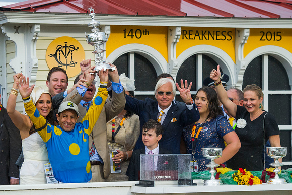 Trainer Bob Baffert celebrates winning four Preakness Stakes races while hoisting the trophy high with the connections after winning the Xpressbet.com Preakness Stakes (GI) with American Pharoah at Pi