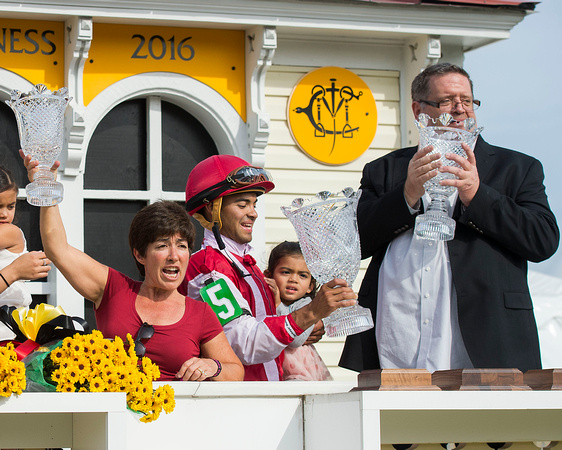 Tammy Fox (left), Luis Saez (center) and Dale Romans (right) celebrate in the Pimlico Cupola winners circle after winning the Black Eyed Susan stakes with Go Maggie Go at Pimlico Race Course in Baltim