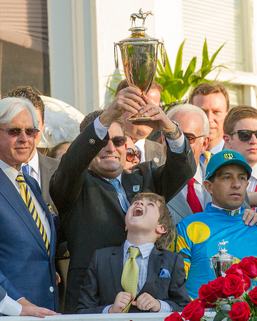Jimmy Barnes, assistant to trainer Bob Baffert, hoists the trophy in the winners' circle after American Pharoah won the Kentucky Derby (Gi) at Churchill Downs in Louisville, Kentucky.