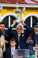 Bob Baffert hoists the Preakness trophy high after winning the Xpressbet.com Preakness Stakes (GI) aboard American Pharoah at Pimlico Race Course in Baltimore, Maryland.
