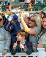 Trainer Bob Baffert kisses his wife Jill while he raises the Triple Crown trophy in the winner's circle after winning the 147th Belmont Stakes (GI) and the Triple Crown.