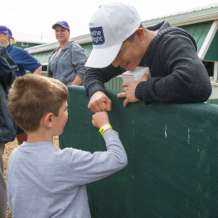 Mario Gutierrez, regular rider of Preakness favorite Nyquist, greets a young fan at Pimlico Race Course in Baltimore, Maryland.