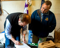 Trainer Doug O'Neill, signs the entry form for Kentucky Derby favorite Nyquist as Racing Secretary Ben Huffman watches.