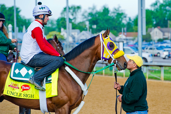 Uncle Sigh gets a kiss from his groom prior to exercising in preparation for the 140th Kentucky Derby.